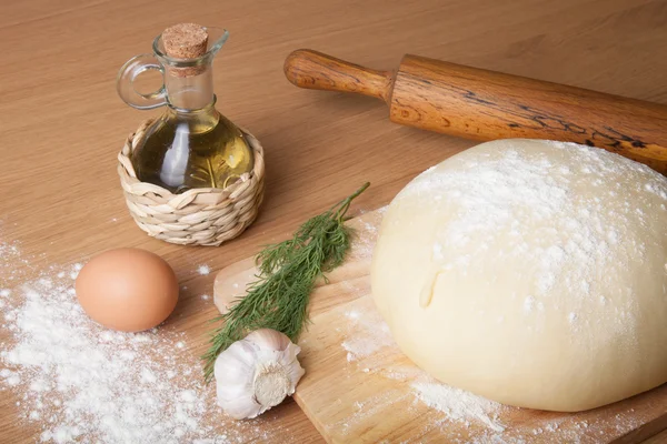 Pasta su una tavola con farina. olio d'oliva, uova, mattarello, garli — Foto Stock