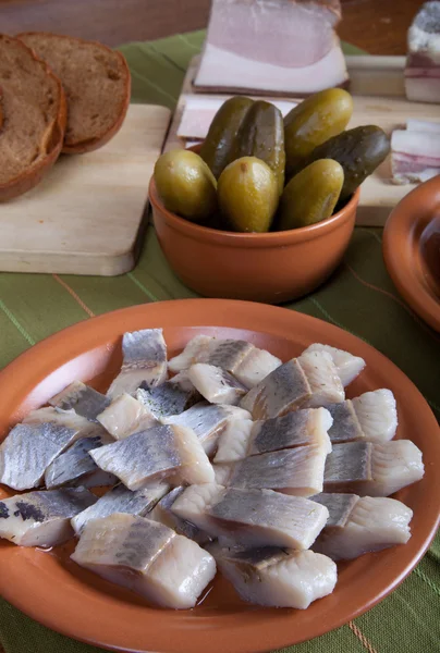 Sill, bröd, pickles och bacon med plattor på en grön servett — Stockfoto