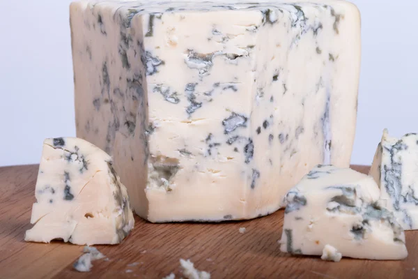 Синий сыр с ломтиками на деревянной доске. Мелкая глубина резкости — стоковое фото