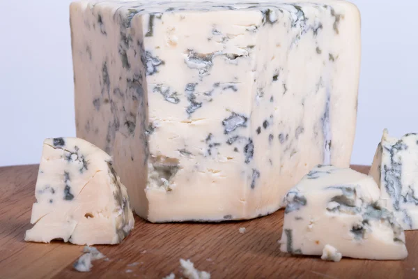 Queso azul con rodajas sobre tabla de madera. Profundidad superficial del campo —  Fotos de Stock