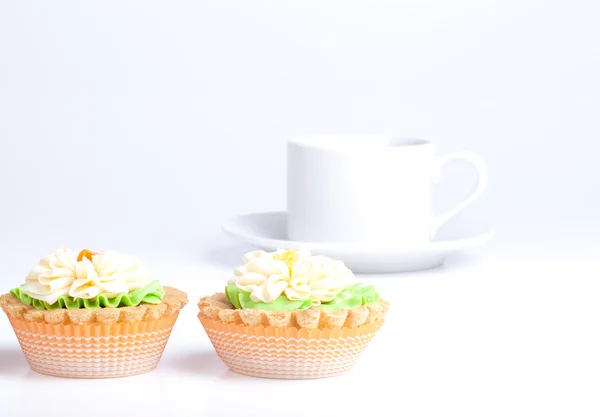 Dos cestas de pastel en una mesa con taza blanca — Foto de Stock