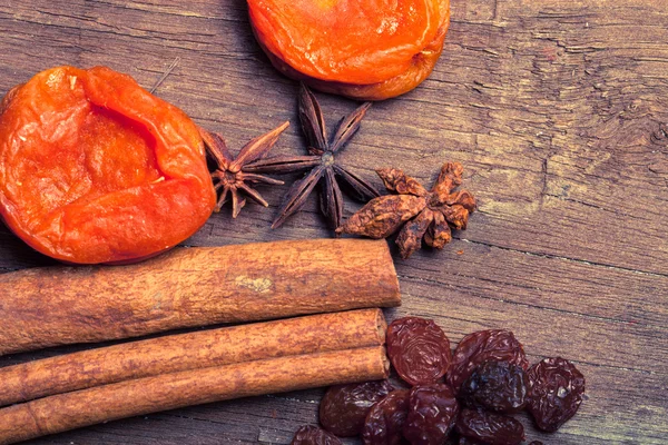 Raisins, cinnamon, anise and dried apricots lying on an old wood — Stock Photo, Image