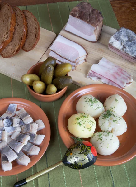 Herring, bread, pickles and bacon on a green napkin — Stock Photo, Image