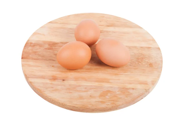 Three eggs on a wooden board isolated on white background — Stock Photo, Image