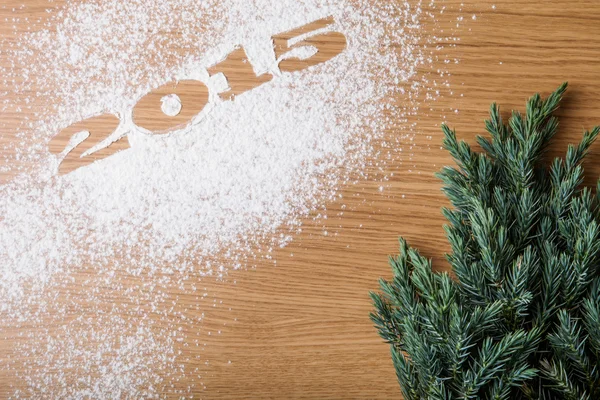 Inscriptie 2015 op meel en kerstboom op een houten tafel — Stockfoto
