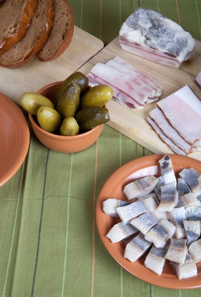 Aringhe, pane, sottaceti e pancetta su un tovagliolo verde — Foto Stock