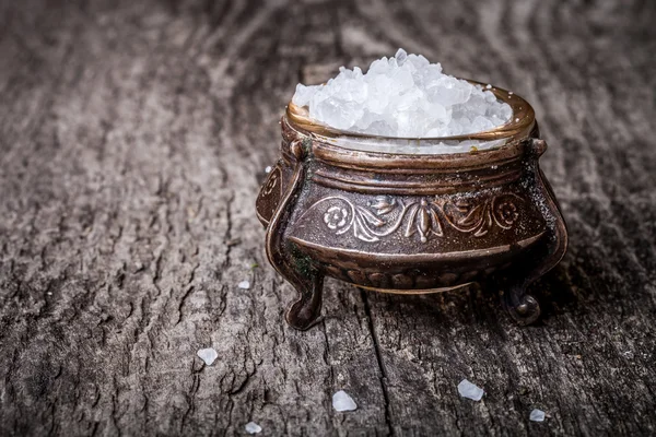 Sea salt in a large antique salt shaker on old wooden tabl — Stock Photo, Image