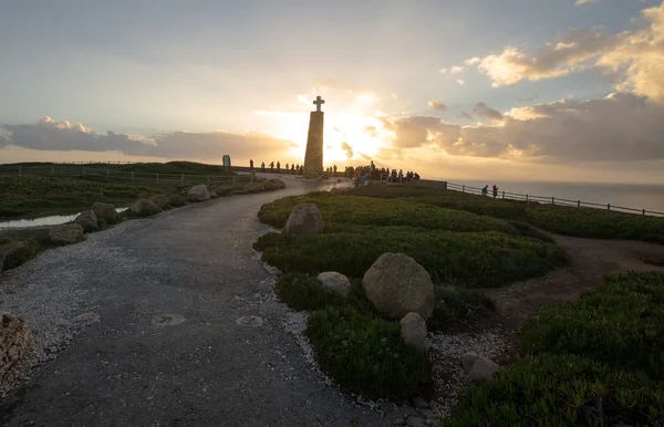 Turistas observando la puesta de sol cerca del monumento de la cruz en Cabo da — Foto de Stock