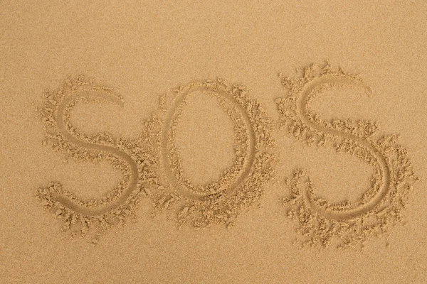 SOS - Iscrizione sulla sabbia della spiaggia tropicale — Foto Stock
