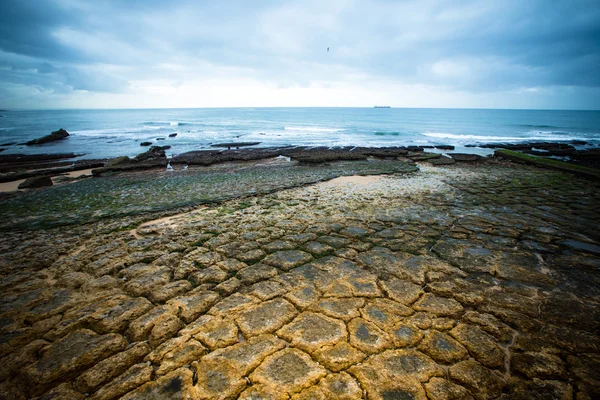 Dramatiska Atlantkusten vid lågvatten. knäckt stenar. — Stockfoto