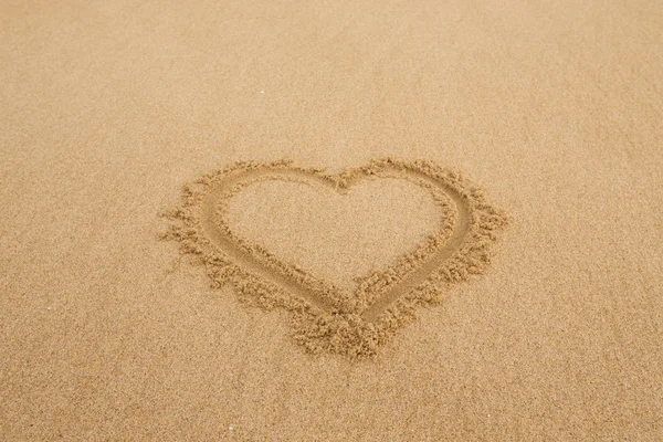 Drawing a heart on wet golden beach sand — Stock Photo, Image