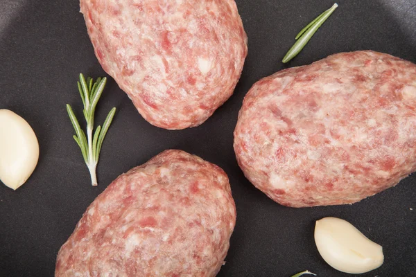 Uncooked patties in a frying pan — Stock Photo, Image