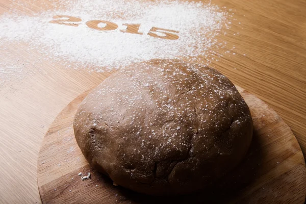 Inscription 2015 on flour and dough on a wooden table — Stock Photo, Image