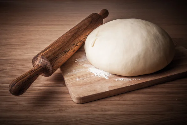 Rolo de pino e massa em uma mesa de madeira. levemente matizado — Fotografia de Stock