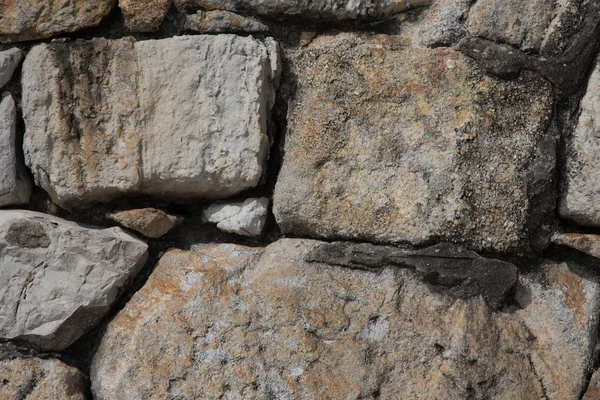 Natursteiner er foldet sammen i vegger. Bakgrunn . – stockfoto
