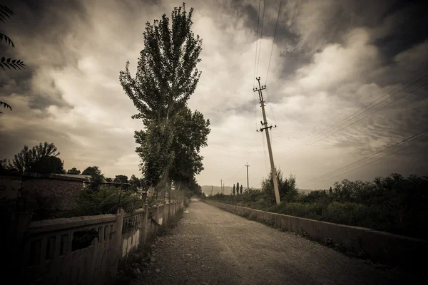 Драматическая сельская дорога. Таджикистан. Темными красками — стоковое фото