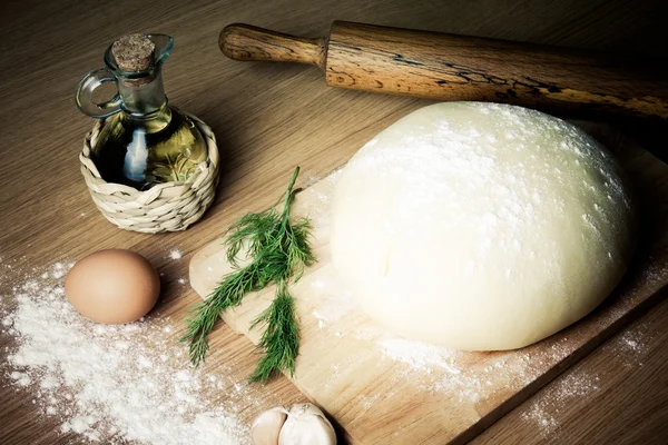Teig auf einem Brett mit Mehl. Olivenöl, Eier, Nudelholz, Garli — Stockfoto