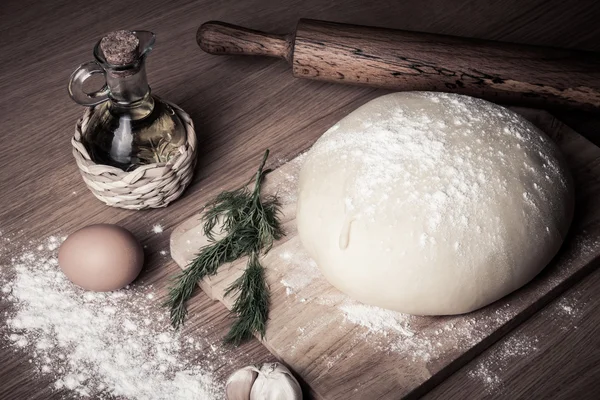 Teig auf einem Brett mit Mehl. Olivenöl, Eier, Nudelholz, Garli — Stockfoto