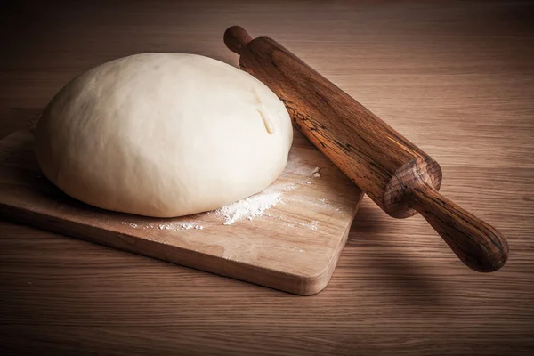 Rolo de pino e massa em uma mesa de madeira. levemente matizado — Fotografia de Stock