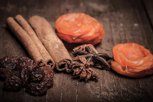 Raisins, cinnamon, anise and dried apricots lying on an old wood — Stock Photo, Image