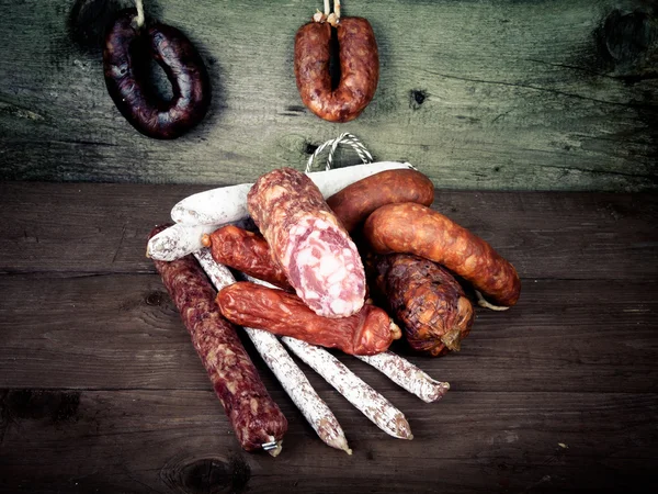 Several types of sausages on a wooden background.tinted — Stock Photo, Image