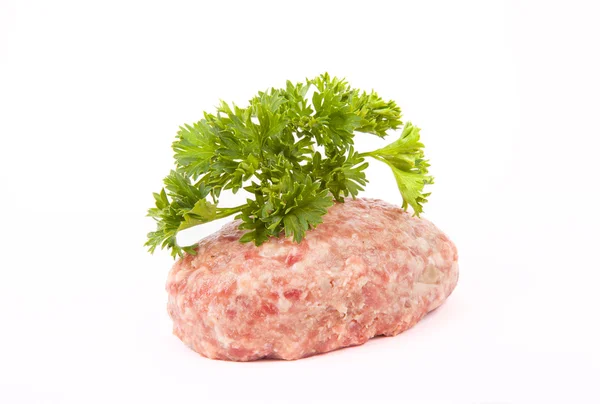 Chuleta de carne cruda con una ramita de perejil sobre un fondo blanco —  Fotos de Stock