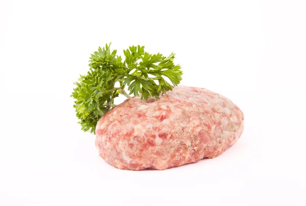 Raw meat cutlet with a sprig of parsley on a white background — Stock Photo, Image