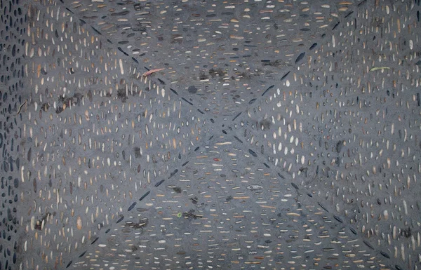 The texture of the road with patterns of river rocks and fallen — Stock Photo, Image