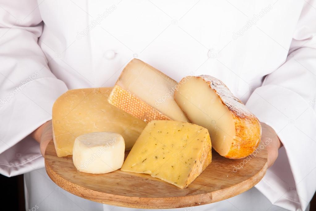 different varieties of cheese on a board in the hands from the c