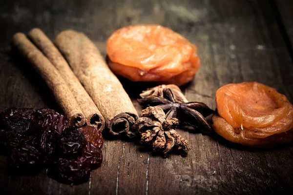 Skořice, rozinky, sušené meruňky na dřevěný stůl. Mělký oddělení — Stock fotografie