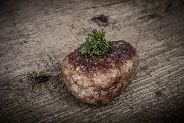 Costeleta com folhas de salsa na mesa de madeira velha . — Fotografia de Stock