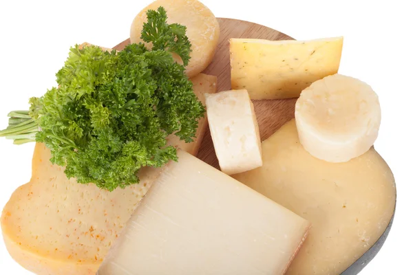Olika ostar och en massa persilja liggande på en styrelse isolat — Stockfoto