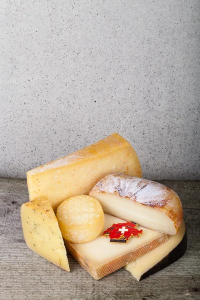 頭と木製のテーブルの上のチーズのさまざまな部分。垂直方向 — ストック写真