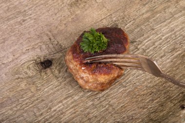 pirzola ve eski ahşap masa üzerinde bir çatalı slice.