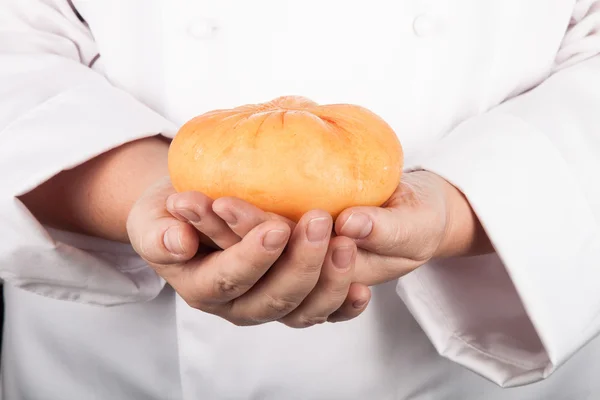 Huvudet ost i händerna på kocken — Stockfoto