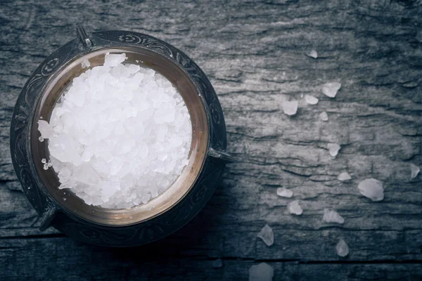 Sea salt in an old utensils on wooden table.tinted — Stock Photo, Image