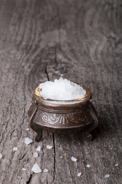 Sea salt in an old utensils on wooden table.tinted.vertical — Stock Photo, Image