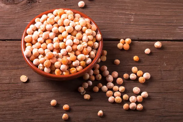 Pois secs dans un bol sur une vieille table en bois — Photo