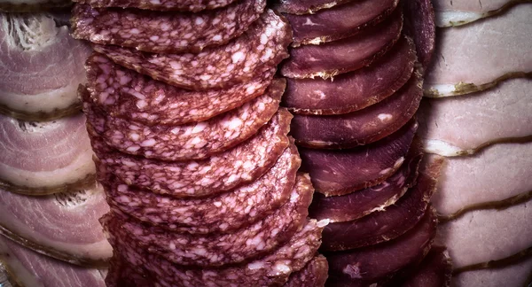 Tło - detal plasterki salami. przyciemniane — Zdjęcie stockowe