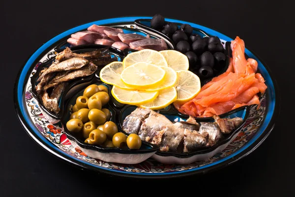 Assorted fish on a plate on a dark background. — Stock Photo, Image