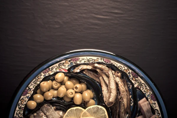 Assorted fish on a plate on a dark background. With space for te — Stock Photo, Image