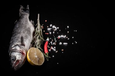 Taze deniz balığı koyu arka plan üzerinde baharatlarla yalan. T için alan