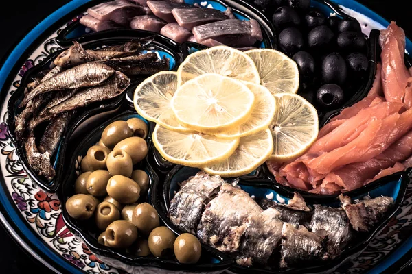Ассорти рыбы на тарелке на темном фоне . — стоковое фото