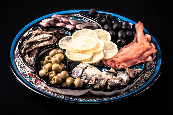 Assorted fish on a plate on a dark background. — Stock Photo, Image