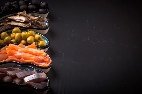 Рыбный ассортимент и оливки на тарелке на темном фоне. С — стоковое фото