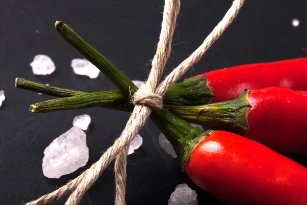 Tre relaterade garn röd varm paprika på en svart tavla tonade — Stockfoto