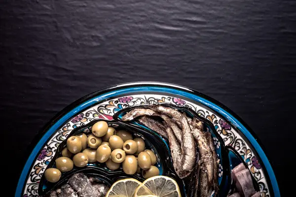 Assorted fish on a plate on a dark background. With space for te — Stock Photo, Image