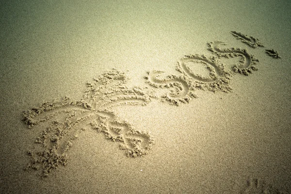 S.o.s im sand.beach Hintergrund geschrieben. Ansicht von oben. getönt — Stockfoto