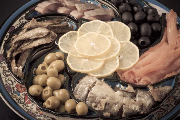 Ассорти рыбы на тарелке на темном фоне. тонированные — стоковое фото