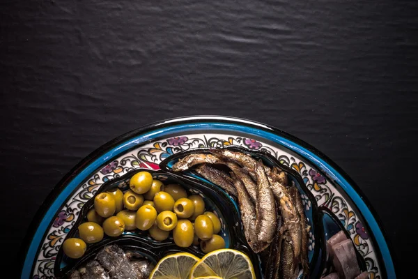 Assorted fish on a plate on a dark background. With space for te — Stock Photo, Image